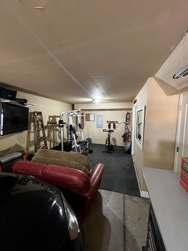 Back of garage with private gym and storage closet (brown chair, ladder and planer not included) - 4789 E 98th Pl