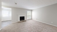 Located at 3600 Park Lake Ln in Peachtree Corners, GA, this single-story, 2-bedroom, 2-bathroom home offers a well-organized and functional layout. The entrance opens into a spacious combined living and dining area highlighted by vaulted ceilings, neutral carpet, and a charming stone-hearth fireplace with a classic white mantle. Natural light flows in through large windows dressed with blinds, enhancing the open, airy feel of the main living space. The galley-style kitchen is thoughtfully updated with white shaker cabinetry, granite countertops, a stainless steel sink with brushed gold fixtures, and stainless steel appliances including a refrigerator and dishwasher, all set on wood-look tile flooring. A dedicated den provides additional flexible living space. Both bedrooms are carpeted and feature neutral walls and ample natural light, with the primary bedroom offering a generous footprint. The two bathrooms are finished with granite vanity tops, undermount sinks, and brushed nickel fixtures, with one bath including a full tub/shower combo. A dedicated laundry room with shelving and in-unit washer hookups adds everyday convenience. Five closets throughout provide abundant storage.