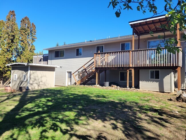 Vista trasera de la casa que muestra una casa de juegos para niños debajo de la cubierta. - 5095 SW 163rd Ave