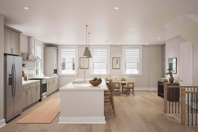 La elegante cocina comedor de Fenland Townhomes ofrece un diseño espacioso con una isla grande, acabados de alta gama y una despensa y estación de café dedicadas para la vida moderna. - Fenland Townhomes