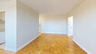 Located at 121 Minerva Ave in Toronto's Scarborough neighbourhood, this one-bedroom, one-bathroom unit offers a well-organized layout across a single floor. Warm parquet flooring flows consistently throughout the living room, hallway, and bedroom, lending the space a classic, cohesive character.

The bright living room is a standout feature, with a large picture window that fills the room with natural light and offers open views of the surrounding neighbourhood. Access to the private balcony extends the living area outdoors, providing elevated city and skyline views.

The galley-style kitchen is efficiently designed with white cabinetry lining both walls, marble-patterned countertops, white appliances including a coil-top stove, dishwasher, and refrigerator, and light tile flooring. A pass-through opening connects it to the rest of the unit.

The bedroom is a comfortable, well-proportioned room featuring parquet flooring, a window with natural light and outdoor views, a radiator for heating, and a built-in sliding-door closet for ample storage.

The bathroom is clean and functional, featuring a combined tub and shower with white tile surround, a vanity with mirrored medicine cabinet, and tile flooring. A radiator provides year-round comfort throughout the unit.