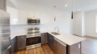 Located at 1701 Federal St in Philadelphia's Point Breeze neighborhood, this one-bedroom, one-bathroom unit offers a well-designed, modern living space across a single floor. The open-concept layout connects the kitchen and living area, creating an efficient and functional flow throughout.

The kitchen is a standout feature, equipped with stainless steel appliances including a refrigerator, electric range, built-in microwave, and dishwasher. Dark lower cabinetry is paired with white upper cabinets and crisp white quartz countertops, complemented by a herringbone-pattern tile backsplash. A peninsula with a stainless steel sink and pendant lighting above adds both style and practicality. Warm hardwood-style flooring runs throughout the kitchen and living areas.

The bedroom is a bright, cozy retreat with the same hardwood-style flooring, clean white walls, recessed lighting, and windows that invite natural light and neighborhood views.

The bathroom features a soaking tub and shower combination with floor-to-ceiling large-format tile in a neutral stone-like finish, offering a clean and spa-inspired aesthetic.

Throughout the unit, recessed lighting, crisp white walls, and consistent flooring create a cohesive, contemporary atmosphere suited for modern urban living.