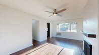 Located at 1801 W Garvey Ave in Alhambra, CA, this one-bedroom, one-bathroom unit offers a well-planned layout spread across a single floor. Wood-style flooring runs throughout, complementing the clean white walls and textured ceilings found in each room.

The living room is a bright, welcoming space anchored by a classic fireplace with a sleek dark mantle and a ceiling fan overhead. Large windows invite abundant natural light and provide views of the surrounding neighborhood. A door off the living area leads to a private balcony. The living and dining areas flow naturally into one another, creating an open and functional common space.

The galley-style kitchen is a standout feature, showcasing rich dark wood cabinetry, white quartz countertops, a mosaic tile backsplash, and a full suite of stainless steel appliances including a gas range and refrigerator. Recessed lighting and a tray ceiling add architectural character to the space. A pantry provides additional storage.

The bedroom is a comfortable retreat featuring a ceiling fan, wall-mounted AC unit, and a mirrored sliding closet that enhances the sense of space. The bathroom is finished in crisp white tones with a combined tub and shower, a single vanity, and over-toilet cabinetry for added storage. A hallway connects the rooms efficiently, completing this thoughtfully designed home.
