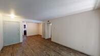 This two-bedroom, one-bathroom unit in Beaumont, Texas is thoughtfully laid out across a single floor, offering a comfortable and functional living space. The open living area is finished with rich, wood-look plank flooring and neutral-toned walls that create a clean, versatile backdrop. A sliding glass door floods the space with natural light and provides direct access to an outdoor patio, offering pleasant views of surrounding greenery.

The galley-style kitchen features dark wood cabinetry with ample upper and lower storage, dark countertops, a double-basin sink, and includes a white refrigerator, range, and dishwasher — all positioned along a corridor layout that maximizes efficiency.

Both bedrooms are carpeted for added comfort and feature neutral walls. One bedroom includes a ceiling fan with light fixture, while the other benefits from a window with blinds that allows natural light to filter in. Each room offers a quiet, restful environment.

The full bathroom is clean and straightforward, featuring a tub/shower combination with white surround, a toilet, and a dark wood vanity with wood-look flooring that ties cohesively to the rest of the unit.

Throughout the unit, HVAC vents are conveniently placed for consistent climate control, making this a well-equipped and practical living space in Beaumont, TX.