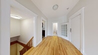 Located in the Westmount area of Montréal, this two-floor residence offers 3 bedrooms and 3 bathrooms thoughtfully distributed across two levels. The upper floor is the more expansive of the two and features warm, honey-toned hardwood flooring throughout the hallways and bedrooms. A bright, open hallway connects the main rooms, with a charming frosted glass-paned door adding a classic architectural touch. The kitchen is equipped with dark wood cabinetry, granite-style countertops, a stainless steel refrigerator, and tile flooring, with a window allowing in natural light. The primary bedroom offers a generous footprint with built-in closet storage and continues the hardwood flooring theme. Additional bedrooms include closet space and light-toned hardwood or laminate flooring, with one featuring a baseboard heating unit and a window overlooking the exterior. The three bathrooms are finished in crisp white tile, including classic black-and-white mosaic floor patterns, white vanities, and mirrored medicine cabinets. A dedicated laundry room houses a stacked Electrolux washer and dryer unit. Two staircases connect the floors, complemented by two hallways that ensure smooth circulation throughout this well-organized and functional Montréal residence.