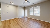 Located at 5555 W 6th St in Lawrence, Kansas, this single-story 2-bedroom, 1-bathroom home offers a clean, modern aesthetic with thoughtful design throughout. The open hallway entry features warm hardwood-style flooring that extends into the living areas, creating a cohesive and inviting flow. The living room is generously sized, filled with natural light from large windows, and equipped with a ceiling fan for year-round comfort. A door provides direct outdoor access, enhancing the sense of openness.

The kitchen is outfitted with crisp white shaker-style cabinetry, striking marble-look countertops, and stainless steel appliances including a smooth-top electric range and over-the-range microwave, delivering a polished, contemporary feel. Both bedrooms feature plush carpeting, ceiling fans, and windows that allow ample natural light. The spacious primary bedroom offers a comfortable retreat with room to accommodate generous furnishings.

The full bathroom includes a tub-shower combination with built-in shelving and hardwood-style flooring. The home also includes three closets, a dedicated laundry area, and a utility room, providing excellent storage and practicality. Neutral wall tones throughout lend a versatile, move-in-ready ambiance.