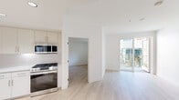 Located at 5570 Rosemead Blvd in Temple City, CA, this modern 3-bedroom, 2-bathroom residence offers a clean, contemporary design throughout. Light wood flooring flows seamlessly across the main living areas, complemented by crisp white walls and an abundance of natural light.

The open-concept kitchen is outfitted with light wood cabinetry, white quartz countertops, a textured subway tile backsplash, stainless steel appliances including a gas range, built-in microwave, and dishwasher, all accented by sleek matte black fixtures. The living area opens directly to a private balcony with views of the community's landscaped courtyard below.

The generously sized primary bedroom features access to a well-appointed en-suite bathroom with a dual-sink vanity, a large LED-backlit mirror, matte black fixtures, and a walk-in closet. A second full bathroom includes a soaking tub with shower, a single-sink vanity, and a large mirror. Two additional bedrooms are bright and well-proportioned with light flooring and ample closet space.

A dedicated laundry room houses a full-size Samsung washer and dryer. The building exterior showcases a modern stucco design with a shared courtyard featuring seating areas, greenery, and a glass-enclosed amenity space.