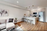 Located at 319 Pennsylvania Ave in Paterson, NJ, this thoughtfully designed one-bedroom, one-bathroom residence offers a well-utilized open-concept layout with modern finishes throughout. Warm hardwood-style flooring flows seamlessly across the entire space, complemented by crisp white walls and recessed lighting that create a bright, contemporary ambiance.

The combined kitchen and living area serves as the heart of the home. The kitchen is outfitted with sleek, light gray cabinetry extending to the ceiling, stainless steel appliances including a gas range, microwave, and French door refrigerator, and a quartz-topped island with a gold-finish faucet that doubles as a casual dining peninsula. The adjoining living area benefits from a large window that brings in natural light.

The bedroom is a comfortable retreat featuring a large window, hardwood-style flooring, and access to a dedicated closet. A second closet provides additional storage convenience. The bathroom is clean and modern, featuring white subway tile surrounding a full soaking tub. An in-unit laundry area adds everyday practicality. The overall design aesthetic is cohesive and contemporary, making this a functional and stylish residence.