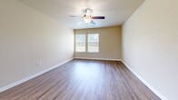 Located at 300 Garden Ln in Weatherford, TX, this single-story, 2-bedroom, 2-bathroom home offers a practical and comfortable layout. The interior features warm neutral tones on the walls paired with wood-look laminate flooring throughout the main living areas and bedrooms, providing a cohesive and easy-to-maintain finish. The kitchen is well-equipped with ample oak cabinetry, granite-look countertops, a full suite of black appliances including a refrigerator, range, microwave, and dishwasher, and large tile flooring that adds a clean, durable surface to the space. The kitchen flows into the living area, creating an open and functional common space. The spacious primary bedroom includes dual closets and a ceiling fan with light, while a window allows for natural light. The second bedroom also features wood-look flooring, a ceiling fan, and a closet. The bathrooms include a walk-in shower with built-in seating in at least one unit. The attached garage is generously sized with an automatic opener, built-in shelving along one wall, and direct interior access, providing ample storage and parking convenience.
