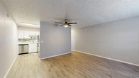 Located at 5327 Timuquana Rd in Jacksonville, FL, this one-bedroom, one-bathroom residence offers a well-organized single-floor layout designed for comfortable everyday living. Throughout the space, warm wood-look vinyl flooring and neutral gray-toned walls create a clean, cohesive aesthetic, while textured ceilings add a subtle decorative touch to each room.

The living area is open and inviting, bathed in natural light from a large window fitted with white blinds. A ceiling fan with a built-in light fixture provides both comfort and illumination. The space flows naturally toward the entry, which features a solid white panel door. The kitchen is efficiently arranged with white cabinetry, stainless steel appliances, and ample counter space, making it practical for daily use.

The spacious primary bedroom is generously sized, offering room for a full furniture arrangement. It includes its own ceiling fan, a window for natural light, and access to two closets, providing excellent storage capacity.

The bathroom is clean and functional, featuring a full tub-shower combination with white tile surround and wood-look flooring that ties into the rest of the home.

Overall, this residence presents a tidy, move-in-ready environment with consistent finishes and a straightforward layout suited to a range of lifestyles.