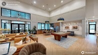 Located at 5900 Bulldog Ln in Carthage, NC, this thoughtfully designed single-floor amenity space offers a generously sized, open-concept layout that seamlessly blends social, recreational, and functional areas under soaring double-height ceilings.

The grand entrance hallway welcomes guests with herringbone-patterned hardwood flooring, wood-accented ceiling details, floor-to-ceiling black-framed glass doors, and tasteful greenery, setting an inviting tone throughout. The expansive main gathering area flows effortlessly between multiple zones, including a comfortable lounge with rich leather sofas, layered area rugs, a large bookcase, and curated artwork illuminated by warm brass wall sconces.

A full kitchen and dining area feature warm wood cabinetry, dark countertops, stainless steel appliances, a large dining table, and dramatic black dome pendant lighting — all framed by oversized windows that flood the space with natural light. Adjacent to the dining area, a billiards table anchors a dedicated game zone, while high-top tables nearby offer casual seating.

A dedicated golf simulator room provides an immersive recreational experience, complete with a full projection screen, a synthetic turf hitting mat, wainscoting detail, and playful golf-themed wallpaper. The overall ambiance of the space is modern and upscale, with a warm, welcoming character suited for community gatherings and leisure.