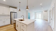 Located at 2220 North Susquehanna Trail in York, PA, this well-appointed 2-bedroom, 3-bathroom residence offers a thoughtfully designed single-floor layout. The open-concept kitchen is a standout feature, showcasing white shaker cabinetry, a classic subway tile backsplash, quartz countertops, stainless steel appliances, and a central island with pendant lighting — all complemented by warm hardwood-style flooring that flows throughout the main living areas. The living room is bright and airy, featuring sliding glass doors with transom windows above that flood the space with natural light and provide access to a private balcony overlooking the community's lush, manicured grounds. Both bedrooms are generously sized, with plush carpeting, ceiling fans, and large windows fitted with blinds. The spacious primary bedroom benefits from its own well-appointed en suite bathroom. All three bathrooms feature clean, modern finishes including white vanities with brushed nickel hardware and light hardwood-style flooring. The overall aesthetic of the residence is crisp and contemporary, with a bright, neutral palette that creates a welcoming and versatile living environment throughout.