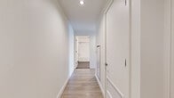 Located in the heart of downtown Los Angeles, this contemporary unit at 1133 S Hope St offers a well-designed single-floor layout that makes efficient use of its space. Light wood-tone flooring flows consistently throughout the living areas, complementing the clean white walls and creating a bright, cohesive aesthetic.

The kitchen is outfitted with stainless steel appliances — including a gas range, built-in microwave, french door refrigerator, and dishwasher — paired with sleek gray flat-front cabinetry, white countertops, and a subtle tile backsplash. The kitchen opens directly into the living area, which benefits from large floor-to-ceiling windows that flood the space with natural light and offer sweeping elevated views of the Los Angeles skyline.

A sliding glass door leads out to a private balcony, where frosted glass privacy panels and open railings frame expansive city views — an ideal outdoor retreat above the urban landscape.

The bathroom features a full soaking tub with a tiled surround and rain showerhead, neutral tile flooring, and a modern vanity with clean white countertops. Throughout the unit, the design remains minimal and modern, emphasizing natural light, city views, and functional living in a prime downtown Los Angeles location.