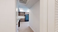 This single-floor unit offers a thoughtfully designed layout with modern finishes and a clean, contemporary aesthetic. The kitchen is a standout feature, showcasing warm medium-toned wood cabinetry extending from floor to ceiling, white quartz countertops, a stainless steel sink, a black electric range with a stainless steel backsplash, and a full-size refrigerator. Light wood-style flooring ties the kitchen together, and a recessed tray ceiling adds a subtle architectural detail overhead.

The bedrooms are bright and comfortable, featuring soft wall-to-wall carpeting and generous windows fitted with horizontal blinds that allow for ample natural light and outdoor views of the surrounding neighborhood. The clean white walls and simple lines create a calm, neutral environment throughout.

The bathrooms maintain the same modern sensibility, with wood-toned vanities, white quartz countertops, large mirrors, and a combination tub and shower. Accessibility features, including grab bars near the toilet and along the tub surround, are thoughtfully integrated without compromising the clean design. Light wood-style flooring in the bathrooms coordinates with the rest of the unit, giving the space a cohesive and polished feel from room to room.