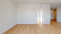 This well-appointed 2-bedroom, 2-bathroom residence at 22 Via Toscana in Salem, NH offers a thoughtfully designed single-floor layout with modern finishes throughout. Light wood-tone flooring flows seamlessly across the entire living space, complemented by crisp white walls and clean architectural lines that create a bright, contemporary aesthetic.

The open-concept kitchen is a standout feature, showcasing white shaker cabinetry, a large quartz-topped center island with pendant lighting, a tile backsplash, and a full suite of stainless steel appliances. Generous windows flood the kitchen and adjoining living area with natural light, and a balcony door extends the living space outdoors with expansive views of the surrounding area.

Both bedrooms are spacious and well-lit, each offering direct access to a private balcony through large sliding glass doors that invite natural light and outdoor views. The primary bedroom provides a comfortable retreat with ample closet storage.

The two bathrooms are finished with clean, neutral tile work. One features a soaking tub with full tile surround, while the other includes a glass-enclosed shower, white cabinetry, and a quartz vanity countertop. Additional conveniences include an in-unit laundry area, multiple closets, and a central hallway connecting all rooms efficiently.