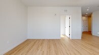 This well-appointed 2-bedroom, 2-bathroom residence at 22 Via Toscana in Salem, NH offers a thoughtfully designed single-floor layout with modern finishes throughout. Light wood-tone flooring flows seamlessly across the entire living space, complemented by crisp white walls and clean architectural lines that create a bright, contemporary aesthetic.

The open-concept kitchen is a standout feature, showcasing white shaker cabinetry, a large quartz-topped center island with pendant lighting, a tile backsplash, and a full suite of stainless steel appliances. Generous windows flood the kitchen and adjoining living area with natural light, and a balcony door extends the living space outdoors with expansive views of the surrounding area.

Both bedrooms are spacious and well-lit, each offering direct access to a private balcony through large sliding glass doors that invite natural light and outdoor views. The primary bedroom provides a comfortable retreat with ample closet storage.

The two bathrooms are finished with clean, neutral tile work. One features a soaking tub with full tile surround, while the other includes a glass-enclosed shower, white cabinetry, and a quartz vanity countertop. Additional conveniences include an in-unit laundry area, multiple closets, and a central hallway connecting all rooms efficiently.