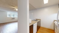 Located at 2707 Portland St in Los Angeles, CA, this 1-bedroom, 2-bathroom unit offers a well-organized, single-level layout designed for comfortable urban living. Warm hardwood-style flooring flows throughout the entire space, complementing the clean white walls and textured ceilings found in each room.

The open living area is generously sized, filled with natural light from large sliding glass doors fitted with vertical blinds that offer views of surrounding greenery. A ceiling fan adds both function and a finishing touch to the room. The kitchen is positioned adjacent to the living area and features dark cabinetry with light countertops, a double sink, a dishwasher, a range, and a full-size refrigerator — all in a practical galley-style layout.

The bedroom is a comfortable, well-proportioned room with a large window providing natural light, and an expansive wall of mirrored sliding-door closets offering substantial built-in storage. Both bathrooms are appointed with dark wood vanities, light countertops, and full tub/shower combinations — one with white tile surround and one with a molded shower unit. Hardwood-style flooring carries into the bathrooms for a cohesive look. A hallway connects the rooms, completing this efficiently designed home.