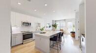 Located at 4312 Yancey Rd in Charlotte, NC, this thoughtfully designed one-bedroom, one-bathroom residence offers a cohesive modern aesthetic across its efficiently utilized single floor. The open-concept layout seamlessly connects the kitchen and living room, creating an inviting, airy atmosphere bathed in natural light from large windows and a glass-panel exterior door.

The kitchen is a standout feature, showcasing two-tone cabinetry — crisp white uppers paired with soft gray lowers — accented by gold hardware. A herringbone tile backsplash, stainless steel appliances, and a generous central island with bar seating make this space as functional as it is visually striking. Light hardwood flooring runs throughout, adding warmth and continuity.

The living room is bright and welcoming, with multiple windows framing outdoor views and allowing sunlight to fill the space. Exposed concrete columns lend an urban, industrial character that complements the otherwise soft, neutral palette.

The bedroom is a calm retreat, featuring natural light from dual windows, light hardwood floors, and an exposed concrete accent wall. A walk-in closet with built-in shelving and hanging rods provides ample storage.

The bathroom offers a clean, refined design with a gray vanity, white quartz countertop, a framed mirror, and a glass-enclosed walk-in shower, with direct access to the walk-in closet.