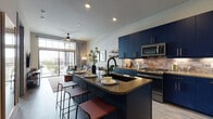 This well-appointed 1-bedroom, 1-bathroom residence offers a cohesive open-concept layout that seamlessly connects the kitchen, dining, and living areas. The kitchen is a standout feature, showcasing bold navy cabinetry with gold hardware, a textured brick-style backsplash, quartz countertops, and a full suite of stainless steel appliances including a gas range, built-in microwave, and French door refrigerator. A spacious island with bar seating provides additional prep space and a natural gathering spot.

The living area is bright and inviting, anchored by a large sliding glass door with transom windows above that flood the room with natural light and open to a private balcony with open views. A ceiling fan adds comfort to the space.

The bedroom is a serene retreat, featuring light wood-look flooring, dual windows that invite natural light, and ample room for a full furniture arrangement. The bathroom continues the navy cabinetry theme with a matching vanity, an illuminated LED mirror, stone-look tile, and a glass-enclosed walk-in shower with floor-to-ceiling marble-style tile. Light wood-look flooring runs throughout, tying the entire residence together with a clean, modern aesthetic.