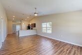 Located on SW Radcliffe Lane in Ankeny, Iowa, this well-appointed 2-bedroom, 2-bathroom single-story home offers a thoughtfully designed layout with a clean, modern aesthetic. The open-concept main living area immediately impresses with vaulted ceilings and rich hardwood-style flooring that flows seamlessly throughout. The kitchen features dark espresso cabinetry, stainless steel appliances, granite-style countertops, and a peninsula with pendant lighting — perfect for casual dining or entertaining. The living area is bathed in natural light from multiple windows offering pleasant outdoor views, and a ceiling fan adds comfort to the space. The primary bedroom is generously sized, featuring vaulted ceilings, hardwood-style flooring, and abundant natural light from dual windows. The secondary bedroom offers plush carpet, a ceiling fan, and its own closet. The home includes four closets total, with walk-in closets outfitted with wire shelving systems for ample storage. Both bathrooms are finished with hardwood-style flooring and neutral tones. A dedicated utility room, a welcoming entrance, and an attached garage with a standard door opener round out the functional layout. The overall ambiance is bright, clean, and move-in ready.