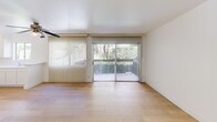 Located in Thousand Oaks, CA, this one-bedroom, two-bathroom residence offers a clean, modern aesthetic throughout its single-floor layout. Light wood flooring runs continuously across all rooms, creating a warm and cohesive feel. The open-concept living and dining area serves as the heart of the home, bathed in natural light from large sliding glass doors fitted with vertical blinds. These doors open to a view of lush greenery, bringing the outdoors in and lending the space an airy, tranquil atmosphere. A ceiling fan adds both function and character to the living area.

The kitchen is positioned adjacent to the living space and features white cabinetry, providing a bright and functional workspace. A hallway connects the main living areas to the private bedroom, which is generously sized with a built-in closet, a window with vertical blinds allowing natural light, and the same warm wood flooring found throughout. The unit includes three closets in total, offering ample storage.

Both bathrooms maintain the clean white palette of the home. One features a full tub-shower combination with chrome fixtures, while the other includes a vanity with a large mirror and built-in drawers. The overall design is minimal, bright, and well-organized, making efficient use of the available space.
