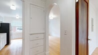 Located at 16 Chapel Road in Buffalo, NY, this single-floor, one-bedroom, one-bathroom unit offers a well-organized layout with classic architectural character. Warm hardwood floors run throughout the space, complementing the crisp white walls and crown molding details visible in multiple rooms.

The galley-style kitchen is a functional highlight, featuring white shaker cabinetry extending to the ceiling, white quartz countertops, stainless steel appliances including a refrigerator, electric range, and dishwasher, along with a wall-mounted range hood. Natural light filters in through a window at the end of the kitchen, brightening the space.

The bedroom is a comfortable, well-proportioned room with hardwood flooring, crown molding, a natural wood door, and a window fitted with blinds that provides views of the surrounding brick neighborhood. A baseboard heating unit runs along the wall, ensuring warmth during Buffalo's colder seasons.

The bathroom is clean and bright, finished with white subway tile in the tub surround, a full bathtub, and a window that allows for natural ventilation and light. The overall palette is crisp and neutral.

The layout is completed by a connecting hallway that ties the rooms together efficiently. The space carries a tidy, classic feel suited to comfortable everyday living.
