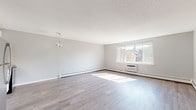 Located at 270 Laurel St in Hartford, CT, this thoughtfully updated single-floor unit offers a bright and contemporary living experience. The open-concept layout is anchored by generously sized living areas finished with durable wood-look flooring in a cool gray tone, complemented by neutral gray walls and textured ceilings that add subtle character throughout.

Natural light flows freely through large windows that frame views of the surrounding neighborhood, with wall-mounted HVAC units and baseboard heating providing year-round comfort. A modern star-shaped light fixture adds a stylish focal point to the main living space.

The kitchen is well-appointed with crisp white shaker-style cabinetry, gray stone countertops, a white subway tile backsplash, and stainless steel appliances including a refrigerator, electric range, and microwave. A single-basin stainless steel sink with a pull-down faucet completes the clean, functional design.

The bathroom continues the fresh, modern aesthetic with floor-to-ceiling white subway tile surrounding a full soaking tub and shower combination, chrome fixtures, and a small window that brings in natural light. The overall ambiance of the space is clean, light-filled, and move-in ready, reflecting a cohesive modern sensibility throughout.