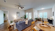 Located in Palmetto, Florida, this thoughtfully designed single-story home offers a comfortable and functional layout across two bedrooms and three bathrooms. The open-concept kitchen and living area serves as the heart of the home, where rich dark-wood cabinetry pairs with crisp white countertops, stainless steel appliances, and a generously sized island with bar seating — all illuminated by stylish pendant lighting. The living room flows naturally from the kitchen, featuring warm wood-look flooring, a ceiling fan, and neutral tones that create a relaxed, airy ambiance. The primary bedroom is a well-proportioned retreat filled with natural light from large windows, complemented by a ceiling fan and direct access to its own bathroom. The primary bath includes a soaking tub, a tiled walk-in shower, and a dual-sink vanity with white cabinetry. The second bedroom is equally bright and comfortable, with outdoor views and easy access to an additional bathroom. A versatile flex room with natural light serves well as a home office or sitting area. Two closets and a dedicated utility room add practical storage throughout. Consistent wood-look flooring ties the entire home together in a clean, modern aesthetic.