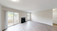 Located at 33410 Hampton Point Dr in Silver Spring, MD, this well-appointed 2-bedroom, 2-bathroom single-floor home offers a comfortable and functional layout. The inviting living room features light wood-style flooring, a classic wood-burning fireplace with a white mantle, and a sliding glass door that opens to a private balcony overlooking lush greenery, filling the space with natural light. An adjacent area with additional light wood-style flooring provides flexible living or dining space. The kitchen is thoughtfully designed with warm honey-toned wood cabinetry, granite countertops, a white subway tile backsplash, and stainless steel appliances, including a full-size refrigerator. Both bathrooms are finished with light wood-style flooring, warm wood vanities topped with granite, and tiled tub-shower combinations with brushed gold fixtures. The generously sized primary bedroom features plush carpeting, a ceiling fan, and ample closet space, while the second bedroom mirrors the same comfort with carpeting and its own ceiling fan. Two closets provide practical storage throughout. The neutral color palette and clean finishes create a bright, move-in-ready atmosphere throughout the home.