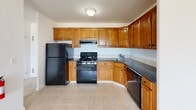 Located along the Jersey Shore at 385 Ocean Blvd in Long Branch, NJ, this one-bedroom, one-bathroom residence offers a well-organized layout with a comfortable sense of space throughout. The open-plan kitchen and living area serves as the heart of the home, with tile flooring in the kitchen and carpet flowing into the living space. The kitchen is well-appointed with warm honey-toned wood cabinetry, dark granite countertops, a tiled backsplash, and black appliances including a gas range, refrigerator, and dishwasher. A structural column subtly separates the kitchen from the living area, which is brightened by a wide multi-pane window offering outdoor views. The spacious bedroom continues the carpeted flooring and features a large window with a baseboard heating unit below, providing views of the surrounding neighborhood. A standout feature is the dual closet system, offering generous built-in shelving and hanging space. The full bathroom is finished with floor-to-ceiling beige tile, a combination tub and shower, a pedestal sink, and a medicine cabinet mirror. A hallway connects the rooms efficiently, completing this well-structured coastal residence.