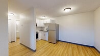 This 1-bedroom, 1-bathroom unit at 303 27th St SW in Austin, MN offers a practical and efficiently designed single-floor layout. Light wood-style flooring runs throughout the living areas, creating a clean, cohesive look that brightens the interior.

The kitchen is outfitted with modern stainless steel appliances, including a refrigerator, electric range, and over-the-range microwave, all complemented by crisp white cabinetry with dark hardware and light-toned countertops. The layout makes efficient use of the available space, providing ample storage and functionality.

The living area is open and versatile, featuring neutral white walls and the same warm wood-style flooring, offering a blank canvas for personalization. The bedroom is a comfortable, well-proportioned space featuring a window that frames outdoor views of surrounding greenery, allowing for natural light. A baseboard heating unit ensures warmth during cooler months.

The bathroom is clean and straightforward, featuring a full tub-shower combo with white surround and chrome fixtures. Throughout the unit, consistent dark baseboards provide a subtle design accent against the neutral walls. Fire-rated entry doors reflect attention to building safety standards, adding a layer of security to this practical and move-in-ready home.
