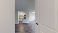 Located at 1330 Danforth Road in Toronto's Scarborough district, this 2-bedroom, 1-bathroom unit offers a clean, modern aesthetic throughout. The open living room is generously proportioned, featuring light wood-tone laminate flooring, crisp white walls, and large windows alongside a sliding glass door that invites natural light and provides access to an outdoor area with views of surrounding greenery.

The kitchen is thoughtfully updated with white shaker-style cabinetry, dark quartz countertops, a white subway tile backsplash, and a full suite of stainless steel appliances including a refrigerator, dishwasher, and stove, making it both functional and stylish.

Both bedrooms are well-sized with the same consistent laminate flooring and neutral white walls. Each room features windows with tree-lined views and baseboard heating units, ensuring comfort year-round. The primary bedroom offers a comfortable footprint suitable for standard bedroom furnishings.

The bathroom is finished with full white subway tile surrounding a soaking tub and shower combo, paired with chrome fixtures for a clean, timeless look. Two hallways connect the rooms efficiently, contributing to the unit's practical layout. The overall ambiance is bright, fresh, and move-in ready, with a cohesive modern design carried throughout the entire space.