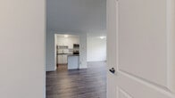Located at 1330 Danforth Road in Toronto's Scarborough district, this 2-bedroom, 1-bathroom unit offers a clean, modern aesthetic throughout. The open living room is generously proportioned, featuring light wood-tone laminate flooring, crisp white walls, and large windows alongside a sliding glass door that invites natural light and provides access to an outdoor area with views of surrounding greenery.

The kitchen is thoughtfully updated with white shaker-style cabinetry, dark quartz countertops, a white subway tile backsplash, and a full suite of stainless steel appliances including a refrigerator, dishwasher, and stove, making it both functional and stylish.

Both bedrooms are well-sized with the same consistent laminate flooring and neutral white walls. Each room features windows with tree-lined views and baseboard heating units, ensuring comfort year-round. The primary bedroom offers a comfortable footprint suitable for standard bedroom furnishings.

The bathroom is finished with full white subway tile surrounding a soaking tub and shower combo, paired with chrome fixtures for a clean, timeless look. Two hallways connect the rooms efficiently, contributing to the unit's practical layout. The overall ambiance is bright, fresh, and move-in ready, with a cohesive modern design carried throughout the entire space.