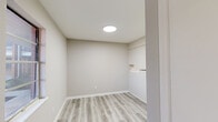 Located at 30 Moore St in Mauldin, SC, this single-story, 3-bedroom, 1-bathroom home offers a clean, modern aesthetic throughout. Light gray wood-look luxury vinyl plank flooring runs consistently across all rooms, creating a cohesive and contemporary feel. Neutral warm-gray paint tones on the walls complement the bright white trim and baseboards throughout.

The galley-style kitchen is well-appointed with white shaker cabinetry, quartz-style countertops, a double stainless steel sink with a brushed nickel faucet, and a black electric range. Built-in shelving provides additional storage.

The spacious primary bedroom receives natural light through a large window and features a built-in closet with a rod for hanging storage. The two additional bedrooms are bright and well-proportioned, each with neutral finishes and access to natural light via windows with exterior views. One bedroom benefits from a round flush-mount ceiling light fixture.

The full bathroom is equipped with a tub-shower combination, a toilet, and a vanity with quartz-style countertops and wood-look flooring. A central hallway connects all rooms, providing an efficient and practical floor plan. The living room is open and airy, illuminated by a ceiling light and a large window facing the outdoors.