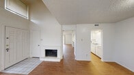 Located in Austin's vibrant 78704 zip code, this two-story, 2-bedroom, 2-bathroom home is thoughtfully laid out across two equally sized floors. The main level features two living areas, both showcasing warm wood-look flooring and textured ceilings. A standout brick fireplace anchors the lower living space, adding classic character to the open feel. Large windows throughout the main floor invite abundant natural light. The galley-style kitchen offers ample white cabinetry on both sides, a gas range, dishwasher, and a sink overlooking a pass-through to the living area. A full bathroom on the main floor includes a tub/shower combo and vanity with storage. Upstairs, the spacious primary bedroom features vaulted ceilings, plush carpet, and a bright window that enhances the airy atmosphere. A second bedroom also offers carpet flooring, a ceiling fan, and a closet with louvered bifold doors. A second full bathroom upstairs provides a vanity with generous counter space. A staircase and hallway connect both levels seamlessly, completing this well-organized and functional home in the heart of South Austin.