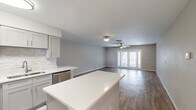 Located at 1400 Donegan Ave in Kissimmee, FL, this single-story 2-bedroom, 3-bathroom home offers a well-designed layout with modern updates throughout. The open-concept living area combines the kitchen, dining, and living room into one cohesive space, anchored by a large white quartz kitchen island. The kitchen features gray shaker-style cabinetry, a herringbone-patterned tile floor, stainless steel appliances including a dishwasher, range, and microwave, complemented by a classic subway tile backsplash. The living room extends from the kitchen and is finished with durable wood-look flooring, a ceiling fan with light, and a set of glass French doors that open to the patio, allowing abundant natural light. The primary bedroom is generously sized, with its own ceiling fan, natural light from a window, and light wood-look flooring. Each bathroom is finished consistently with gray vanity cabinets, white quartz countertops, brushed nickel fixtures, and well-lit mirrors. A dedicated hallway connects the bedrooms and bathrooms, alongside three closets, a laundry area, and a utility room. The home also includes an entrance foyer and an outdoor patio, rounding out a functional and updated living space.