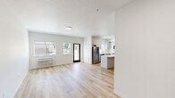 Located at 300 Hoxton Ave in Monmouth, Oregon, this thoughtfully designed apartment offers three bedrooms, two bathrooms, and a combined kitchen and living area across a single floor. Light wood-style flooring runs throughout, creating a warm, cohesive aesthetic complemented by crisp white walls and clean lines.

The kitchen is a standout feature, outfitted with light gray shaker cabinetry, quartz countertops, stainless steel appliances, and a central island that provides additional prep space and a natural gathering point. A window above the sink brings in natural light, enhancing the bright, airy atmosphere.

The bedrooms are well-proportioned and serene, with large windows in several rooms framing picturesque views of open green fields and the surrounding Oregon landscape. The primary bedroom offers a generous footprint, while the additional bedrooms provide comfortable, flexible spaces. Distinctive dark-paneled double doors serve as a stylish accent in one of the bedrooms.

Both bathrooms are finished in a clean, modern style, each featuring a full soaking tub and shower combination with brushed nickel fixtures, a vanity with a light stone countertop, and light wood flooring. The overall design of this residence prioritizes functionality and modern comfort in a bright, neutral palette.