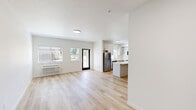 Located at 300 Hoxton Ave in Monmouth, Oregon, this thoughtfully designed apartment offers three bedrooms, two bathrooms, and a combined kitchen and living area across a single floor. Light wood-style flooring runs throughout, creating a warm, cohesive aesthetic complemented by crisp white walls and clean lines.

The kitchen is a standout feature, outfitted with light gray shaker cabinetry, quartz countertops, stainless steel appliances, and a central island that provides additional prep space and a natural gathering point. A window above the sink brings in natural light, enhancing the bright, airy atmosphere.

The bedrooms are well-proportioned and serene, with large windows in several rooms framing picturesque views of open green fields and the surrounding Oregon landscape. The primary bedroom offers a generous footprint, while the additional bedrooms provide comfortable, flexible spaces. Distinctive dark-paneled double doors serve as a stylish accent in one of the bedrooms.

Both bathrooms are finished in a clean, modern style, each featuring a full soaking tub and shower combination with brushed nickel fixtures, a vanity with a light stone countertop, and light wood flooring. The overall design of this residence prioritizes functionality and modern comfort in a bright, neutral palette.