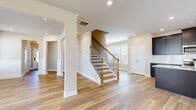 Located at 362 Kilough Church Rd in Dawsonville, GA, this two-story home offers five bedrooms and four bathrooms across two well-proportioned floors. The main level greets visitors with light-toned hardwood-style flooring that flows through the open living areas. A stylish staircase with wood treads and sleek metal balusters connects the floors, anchoring the home's interior design. The kitchen is a standout feature, showcasing rich dark cabinetry, granite countertops, a center island with a built-in sink, stainless steel appliances, and a tile backsplash — all complemented by recessed lighting and direct access to the outdoors. A dedicated hallway connects key rooms on the main floor, with a bathroom featuring hardwood-style flooring, a soaking tub, and a window for natural light. The attached garage provides ample space with a concrete floor and electrical panel access. Upstairs, the larger floor plan houses the majority of the bedrooms, each carpeted for comfort. The generously sized primary bedroom includes a walk-in closet outfitted with wire shelving. Additional bedrooms are bright and well-sized, with neutral tones throughout. The living room benefits from vaulted ceilings, a ceiling fan, and an abundance of windows that flood the space with natural light, creating an airy and welcoming atmosphere.