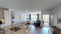 Located at 600 W 14th Ave in Denver's vibrant Golden Triangle neighborhood, this well-appointed single-floor residence combines contemporary design with thoughtful functionality. The open-concept living and dining area is anchored by wide-plank hardwood-style flooring and floor-to-ceiling windows that flood the space with natural light and offer sweeping views of the Denver skyline and surrounding greenery. A private balcony extends the living space outdoors.

The kitchen is a standout feature, showcasing white shaker cabinetry, a mosaic tile backsplash, dark granite countertops, stainless steel appliances, and a generously sized granite island with seating — ideal for both meal prep and casual dining.

The primary bedroom offers plush carpeting, large windows framing city and treetop views, and access to a spacious en-suite bathroom. The primary bath features a dual-sink vanity with dark countertops, wood-style flooring, and a walk-in closet. A secondary bathroom includes a tiled soaking tub and shower combination with built-in shelving. An additional flexible room provides space for a home office or sitting area. Throughout, the unit maintains a cohesive modern aesthetic with neutral tones and quality finishes.