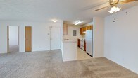 This single-floor, 3-bedroom, 2-bathroom residence in Parkwood offers a functional and straightforward layout designed for comfortable everyday living. The open-concept living area flows directly into the kitchen, which features warm oak cabinetry, white countertops, a peninsula with a sink, and white appliances including a refrigerator and electric range. Light-toned tile flooring runs through the kitchen, while neutral carpet covers the spacious living area and all three bedrooms.

The bedrooms are well-proportioned, each with carpet flooring and natural light from windows. The primary bedroom stands out with two closets—including a generous walk-in closet equipped with wire shelving—and a ceiling fan with light fixture. Additional bedrooms are served by a ceiling fan or overhead light and offer ample wall space.

The two bathrooms are finished with tile flooring and oak cabinetry. One bathroom features a glass-enclosed shower stall with a vanity and mirror, while the second includes a full tub-shower combo. Both are clean and efficiently arranged. Throughout the residence, neutral tones, ceiling fans, and textured ceilings contribute to a practical, move-in-ready atmosphere.