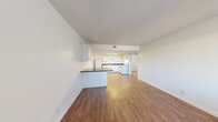 Located at 5055 Jeffreys St in Las Vegas, NV, this ground-floor unit offers a practical and comfortable single-level layout with two bedrooms and two full bathrooms. The open-concept living, dining, and kitchen area creates a welcoming, connected space. Wood-look flooring runs throughout the main living areas, adding warmth and continuity. The kitchen is well-equipped with white cabinetry offering ample storage, dark speckled countertops, a double basin sink, and white appliances including a refrigerator, dishwasher, and electric range. A peninsula counter separates the kitchen from the dining and living area, ideal for casual use. Both bedrooms are carpeted and receive natural light through large windows fitted with vertical blinds. The spacious primary bedroom provides a comfortable retreat, while the second bedroom is equally functional. Each bathroom features a tiled shower-tub combo, wood-look flooring, and clean, neutral finishes. Two dedicated closets and hallway spaces offer practical storage throughout. Textured ceilings are consistent throughout the unit, complementing the clean white walls. The overall aesthetic is bright, neutral, and move-in ready.