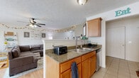 Located at 25 Silverlight Way in Rochester, NY, this multi-level home spans three floors and offers a well-organized layout with 2 bedrooms, 3 bathrooms, a dedicated office, and a full basement. The main living level features an open-concept design where the kitchen, dining room, and living room flow seamlessly together. The kitchen is equipped with stainless steel appliances, warm wood cabinetry, granite countertops, and tile flooring, while a peninsula with a double sink creates a natural divide between the kitchen and the adjacent living area. The living room features hardwood flooring, a ceiling fan, and large windows that bring in generous natural light. The dining area continues the bright, airy feel with wide windows overlooking the outdoors. Bedrooms are carpeted and include closet storage, with the primary bedroom offering a notably spacious footprint. Three bathrooms throughout the home feature wood-toned vanities with solid-surface countertops. A dedicated laundry room with a full washer and dryer adds everyday convenience. The unfinished basement provides substantial additional storage space with concrete block walls and an exposed structural ceiling. A utility room completes the lower level. Two staircases connect the floors, facilitating easy circulation throughout this thoughtfully arranged home.
