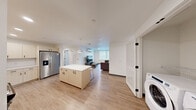Located at 4759 15th Ave NE in Seattle's vibrant University District, this thoughtfully designed 4-bedroom, 4-bathroom unit offers a clean, contemporary aesthetic throughout. The open-concept kitchen and living area serves as the heart of the home, featuring light wood-tone cabinetry, quartz countertops, a center island with pendant lighting, and stainless steel appliances including a French door refrigerator, electric range, and dishwasher. A white subway tile backsplash and matte black fixtures add modern contrast. In-unit washer and dryer are conveniently accessible just off the main living area. The living room offers a comfortable gathering space with a wall-mounted mini-split system and a window overlooking the surrounding neighborhood. Each of the four bedrooms is a private, light-filled retreat with large windows that bring in natural light and views of the exterior streetscape. The bedrooms feature light wood-style flooring and ample space for a bed and desk. Each bedroom is paired with its own private bathroom, finished with quartz vanities, light wood cabinetry, matte black fixtures, and tub-shower combinations with sliding glass enclosures. Light wood-style flooring flows consistently throughout the entire unit, unifying the space with a warm, cohesive feel.