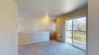 This two-floor residence offers a well-organized layout designed for comfortable everyday living. The main level features a kitchen equipped with white cabinetry, laminate wood-style flooring, a full suite of white appliances including a refrigerator, electric range, and dishwasher, along with ample counter space and a window that brings in natural light. Adjacent to the kitchen, the dining area is accented by a decorative pendant light fixture and opens toward the living space. The carpeted living room is generously sized and connects directly to a private balcony through sliding glass doors, offering views of surrounding greenery. A dedicated laundry room on the lower level houses a full-size washer and dryer with wood-style flooring and baseboard heating. The attached garage provides additional storage and convenience with an automatic opener. Upstairs, the carpeted bedrooms offer comfortable retreats, each with windows that allow natural light to filter in. The bathroom includes a tub and shower combo with sliding glass doors and a window for ventilation. Warm neutral tones, wall heating units, and carpeted staircase with a window landing complete the practical and cohesive character of this multi-level home.