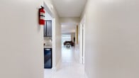 This well-appointed 2-bedroom, 2-bathroom single-floor residence at 8100 Bellaire Blvd in Houston, Texas offers a thoughtfully designed layout that maximizes every inch of its living space. Throughout the home, striking marble-look porcelain tile flooring creates a cohesive and polished aesthetic.

The living room is bright and airy, featuring a large sliding glass door that invites natural light and opens the space visually. The adjacent dining room is an elegant highlight, featuring wainscoting panels, built-in white shelving with display cabinetry, and a statement chandelier overhead.

The kitchen is equipped with dark cabinetry, granite countertops, a stone tile backsplash, black appliances, and a window that brings in natural light. A pantry provides additional storage. Two hallways connect the living areas to the private quarters, which include three closets for ample storage.

The primary bedroom is generously sized, offering two closets and continuity of the marble-look flooring. The second bedroom features a ceiling fan and a bright window. Both bathrooms are functional and well-finished, each with a vanity, granite countertop, and tub-shower combination. The overall ambiance is clean, modern, and move-in ready.