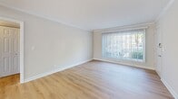 Located at 2619 Hydraulic Rd in Charlottesville, VA, this single-floor, 2-bedroom, 1-bathroom residence offers a practical and well-designed layout with a clean, neutral aesthetic throughout. The living room features light hardwood-style flooring, crown molding, and a large window with vertical blinds that fill the space with natural light and provide outdoor views. A ceiling fan adds a functional touch to this open, airy area. The kitchen is equipped with a gas range, over-the-range microwave, dark granite-style countertops, and warm wood cabinetry, complemented by a window that brings in additional natural light. Both bedrooms are carpeted in a neutral tone and include ceiling fans and windows with outdoor views, creating comfortable, well-lit retreats. The primary bedroom offers a generous footprint and access to a closet. The full bathroom features a clean, white tub-shower combination with brushed nickel fixtures. A hallway connects the main living areas efficiently. Throughout the home, consistent neutral wall tones, white trim, and clean finishes contribute to a cohesive, move-in-ready appearance.