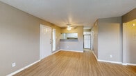 This single-story 2-bedroom, 2-bathroom residence offers a practical and comfortable layout designed for everyday living. The open-concept living room serves as the heart of the home, featuring warm wood-look flooring, neutral tan walls, a textured ceiling, and a ceiling fan. Natural light enters through a window flanked by the front entry door, creating a bright and welcoming atmosphere. A half-wall pass-through seamlessly connects the living area to the kitchen, which is arranged in a galley style with white cabinetry, granite-look countertops, a stainless steel sink, electric range, built-in microwave, dishwasher, and a window that brings in additional natural light.

A hallway leads from the living area to both bedrooms and bathrooms. The primary bedroom is generously proportioned, offering dual windows with outdoor views, light wood-look flooring, and a built-in closet with rod storage. The second bedroom is comparably sized, also featuring light flooring and a window. Both bathrooms are fitted with full tub-shower combinations tiled in classic white with a contrasting black accent border, providing a clean and timeless aesthetic. The consistent flooring, neutral color palette, and thoughtful layout throughout give this residence a cohesive and functional character.