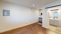 Located at 1520 North Oregon Avenue in Pasco, Washington, this efficiently designed studio unit offers a well-planned single-floor layout that maximizes every square foot. The main living area features warm wood-look flooring throughout, crisp white walls, and recessed lighting that keeps the space feeling bright and open. A window with blinds allows natural light to filter in while offering a view to the exterior, and a wall-mounted HVAC unit provides year-round climate control. The compact kitchenette is tucked neatly into one corner, outfitted with white cabinetry, a stainless steel microwave, a sink, and stainless steel appliances — a functional setup that makes efficient use of the available space. A sliding barn-style door leads to the bathroom, which serves as a standout feature of the unit. The bathroom is finished with white subway tile walls, neutral stone-look tile flooring, and a clean white vanity with ample cabinet storage topped by a well-lit mirror. A corner glass-enclosed shower with dark hardware fixtures adds a modern, polished touch. The overall design is clean, contemporary, and functional, making this a practical and comfortable studio in Pasco, WA.