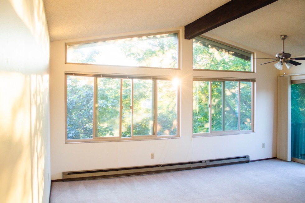 Sala de estar repleta de luz con techos abovedados y ventanas adicionales. - Wingate Apartments